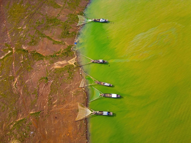 Vista superior da aldeia de pescadores de Ben Nom imagem verde fresca da temporada de algas verdes no lago Tri An com muitos barcos de pesca tradicionais ancorados em Dong Nai, Vietnã