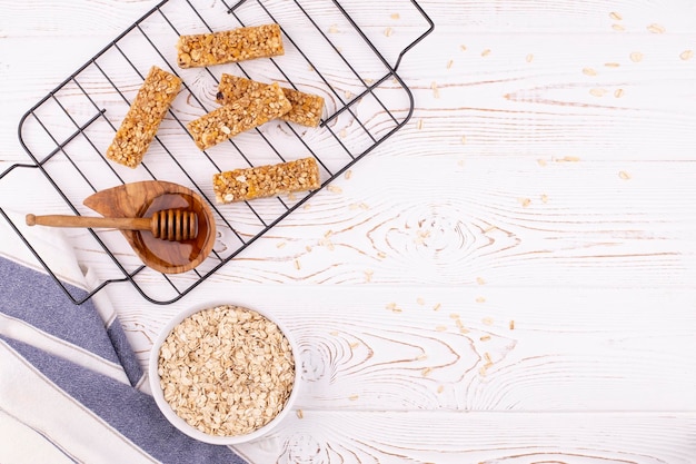 Vista superior da barra de muesli de cereais com nozes e mel em uma mesa de madeira branca lanche doce saudável