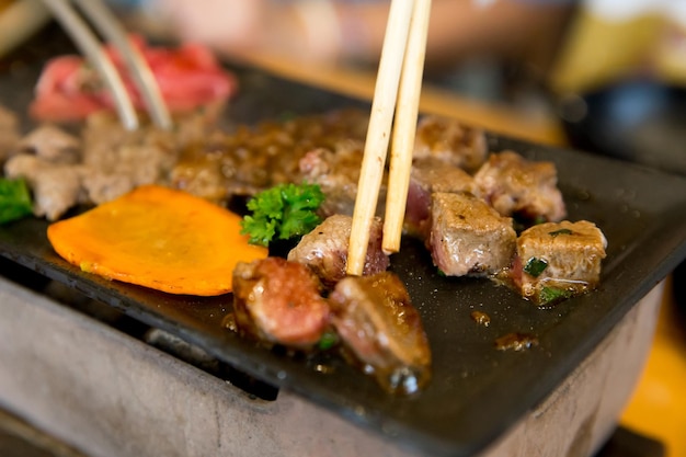 Vista superior da carne de dados na panela quente com pauzinhos