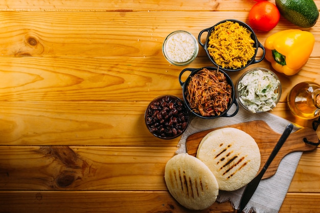 Vista superior da comida sul-americana chamada arepa e diferentes ingredientes