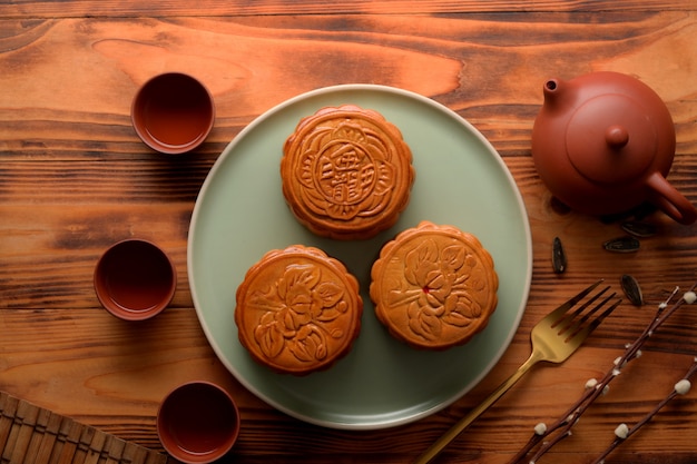 Vista superior da configuração de mesa com bolos de lua e jogo de chá no festival da lua. Caracteres chineses no bolo da lua representam "cinco grãos e porco assado" em inglês