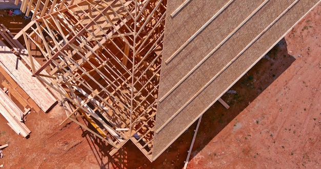 Vista superior da construção trabalhando nas vigas do telhado da casa de madeira em construção