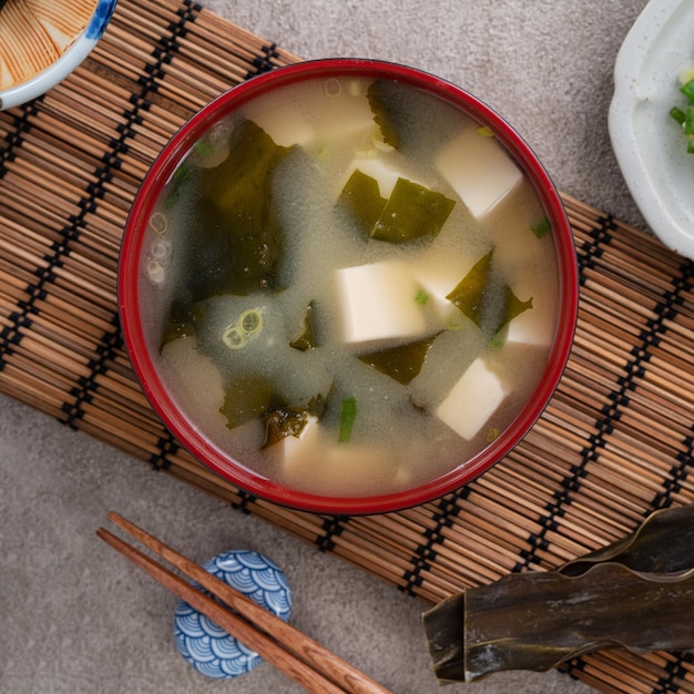 Vista superior da deliciosa sopa de missô japonesa saborosa em uma tigela preta para comer