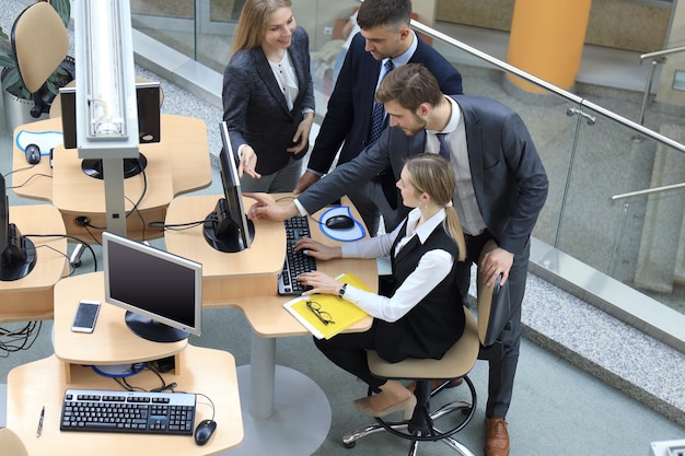 Vista superior da equipe de negócios brainstorming enquanto estão sentados à mesa do escritório juntos.