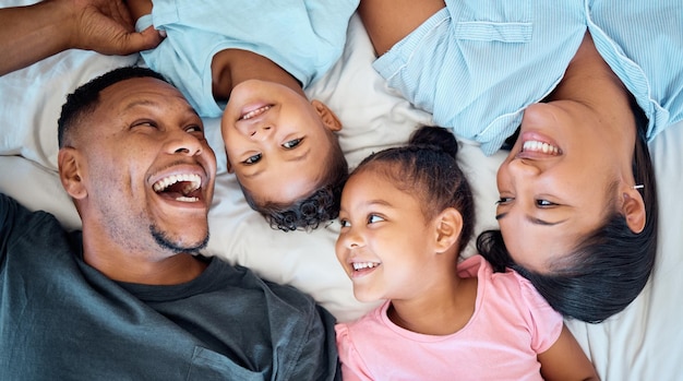 Vista superior da família ou filhos se unindo no quarto da casa ou relaxe no hotel em confiança amor e apoio à segurança Sorria crianças felizes ou rindo com os pais pai ou mãe no apartamento indonésio