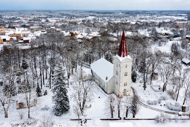 Vista superior da Igreja Luterana na pequena cidade letã de Kandava em um dia de inverno nevado