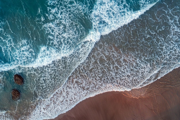 Vista superior da linha de surf. Ondas do mar e praia de areia