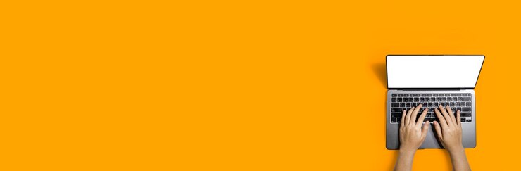 Vista superior da mão de uma pessoa digitando uma mensagem em um laptop em sua mesa, copie o espaço para anúncios em banner, isolado em um fundo laranja e traçado de recorte.