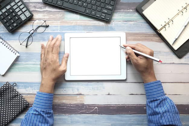 Vista superior da mão do homem trabalhando em tablet digital na mesa do escritório.