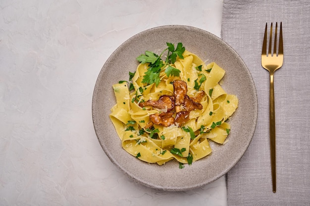 Vista superior da massa italiana pappardelle com cogumelos, queijo chanterelles e salsa no prato com