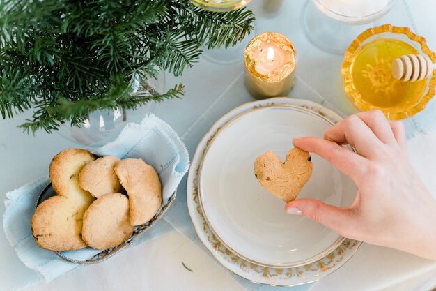 Foto vista superior da mesa com decoração e biscoito de coração de amor.