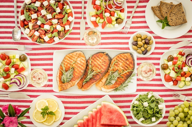 Vista superior da mesa com peixes, saladas, frutas e vegetais