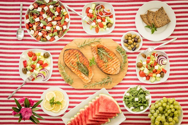 Vista superior da mesa com peixes, saladas, frutas e vegetais