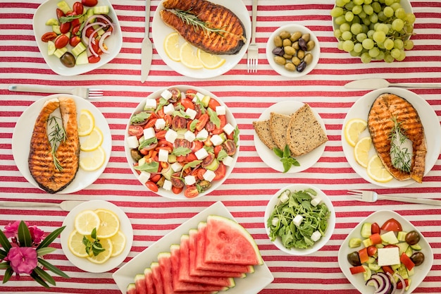 Vista superior da mesa com peixes, saladas, frutas e vegetais