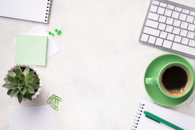 Foto vista superior da mesa com planta suculenta e artigos de papelaria