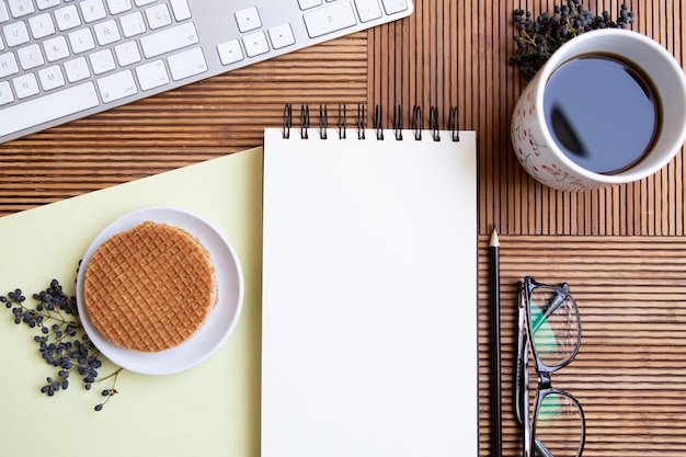 Foto vista superior da mesa da escrivaninha com café, bloco de notas e teclado