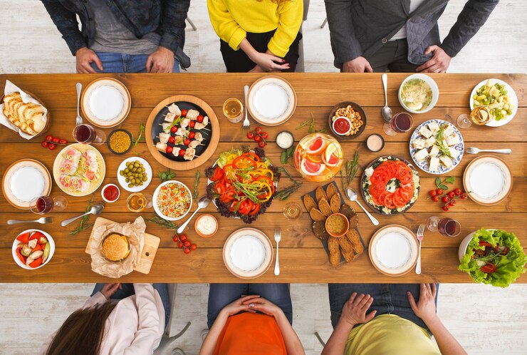 Foto vista superior da mesa de jantar de amigos. as pessoas comem comida saudável juntas, festa em casa