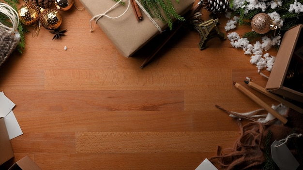 Vista superior da mesa de madeira com espaço de cópia, caixa de presente e decorações no conceito de Natal