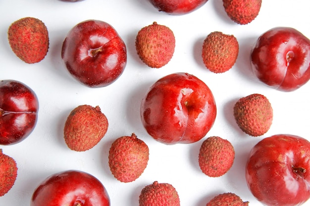 Vista superior da mistura de frutas ameixa vermelha e lichia em fundo branco