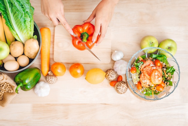 Vista superior da mulher mãos salada fresca de preparação na mesa