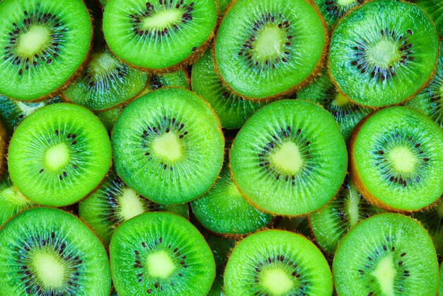 Foto vista superior da pilha de kiwis fatiados como plano de fundo texturizado