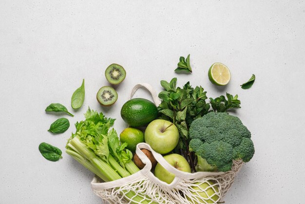 Vista superior da sacola de compras de malha com frutas e legumes ecológicos verdes orgânicos