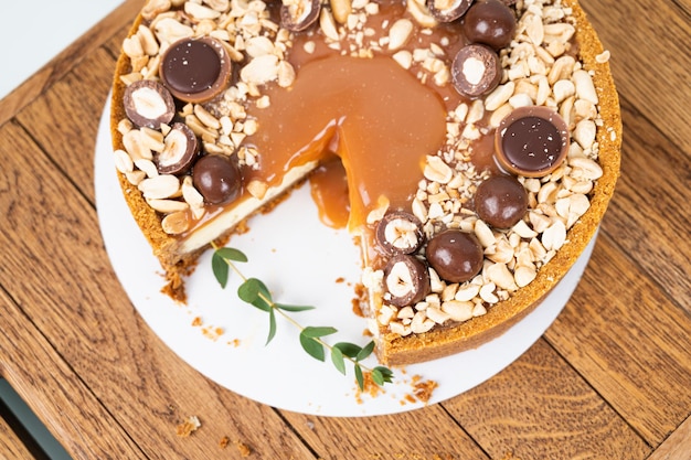 Vista superior da torta redonda com caramelo salgado e nozes na seção pedaço de bolo no carrinho de madeira Conceito de cozimento caseiro