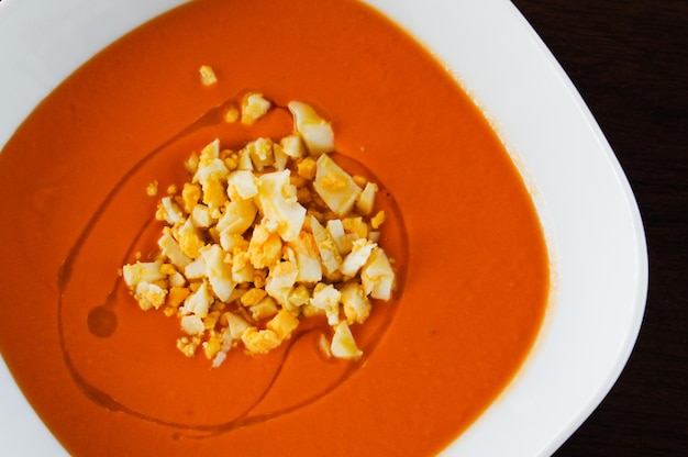 Vista superior da tradicional sopa de tomate salmorejo espanhol com pedaços de ovo cozido e gota de azeite