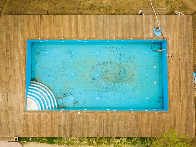 Vista superior da velha piscina azul suja cuidando das piscinas externas