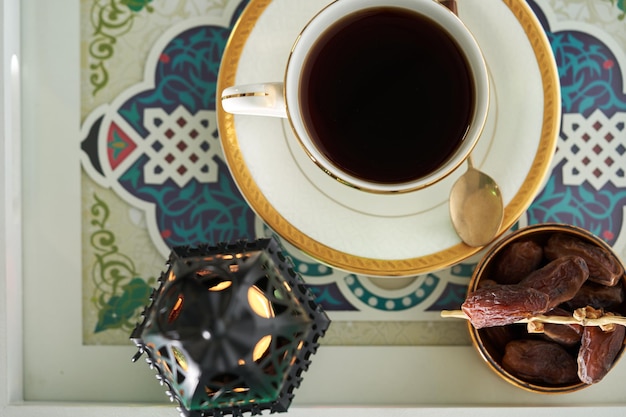 Vista superior da xícara de lanterna árabe de chá quente e data de frutas secas na bandeja