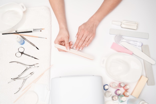 vista superior das ferramentas de manicure e Mulher preparando as mãos para fazer o procedimento de manicure