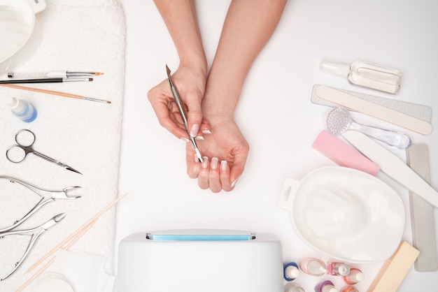 vista superior das ferramentas de manicure e Mulher preparando as mãos para fazer o procedimento de manicure