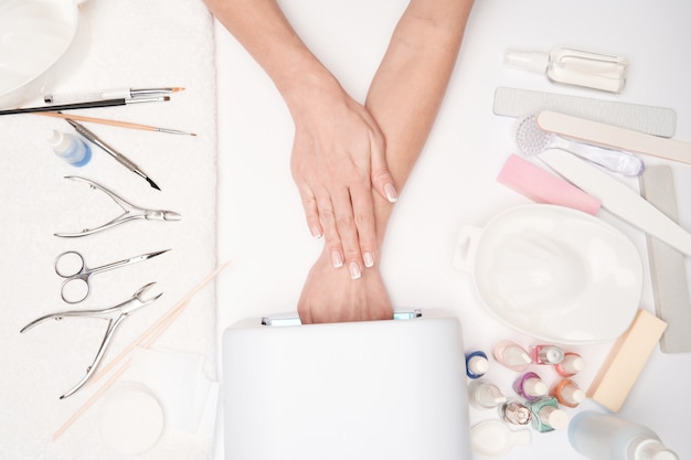 vista superior das ferramentas de manicure e Mulher preparando as mãos para fazer o procedimento de manicure