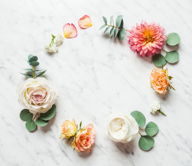 Foto vista superior das flores do casamento no fundo de mármore. maquete para convite de aniversário, plantas no círculo