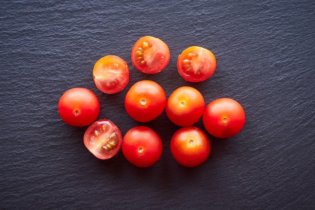 Vista superior de alguns tomates cereja em uma mesa escura