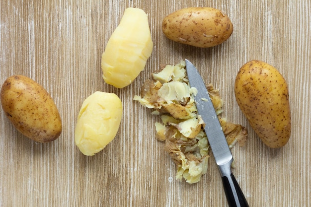 Vista superior de batatas cozidas em jaquetas e esfregadas no fundo de madeira