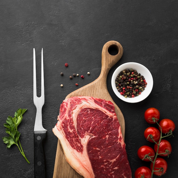 Foto vista superior de bife fresco na mesa com tomate cereja