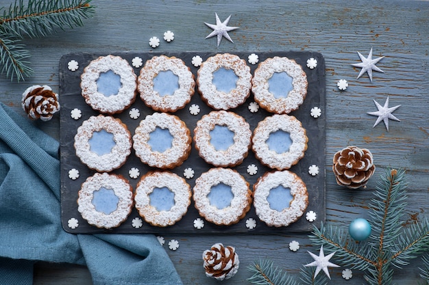 Vista superior de biscoitos Linzer de flores com vidros azuis no inverno escuro