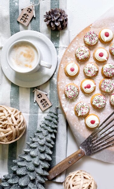 Vista superior de bolos para o Ano Novo e Natal com uma chávena de café na mesa branca