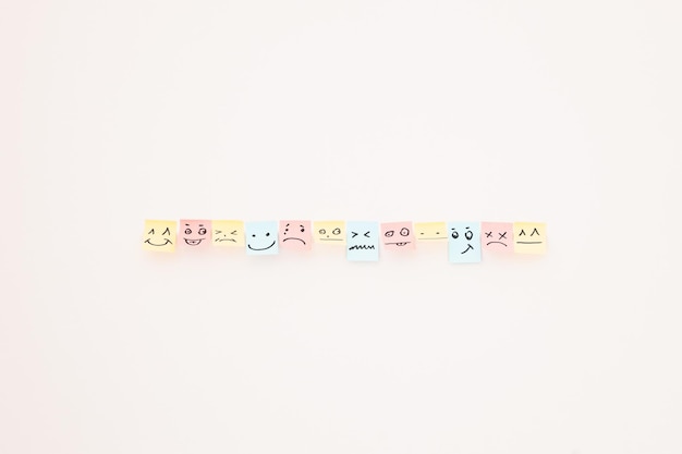 Vista superior de cartões de papel com vários smileys em fundo branco