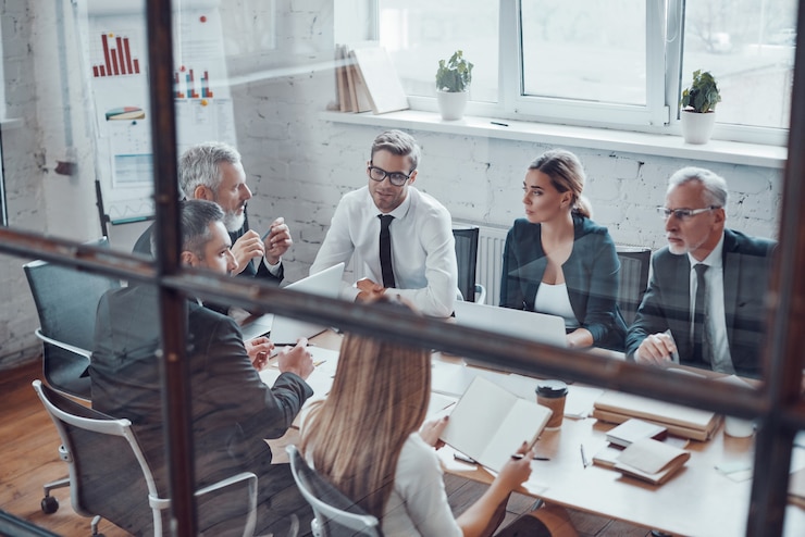 Foto vista superior de colegas de trabalho discutindo a próxima etapa do negócio enquanto trabalhava com colegas em um escritório moderno