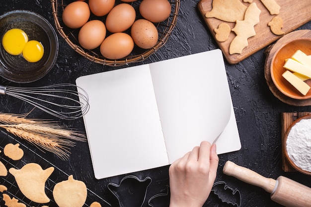 Vista superior de como fazer sobremesas de halloween lendo o livro de receitas