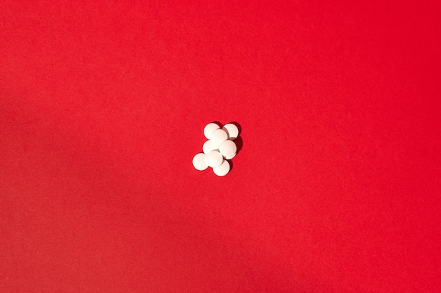 Vista superior de comprimidos isolados em um fundo vermelho