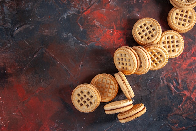 Vista superior de deliciosos biscoitos de açúcar no lado esquerdo no fundo da mistura de cores com espaço livre