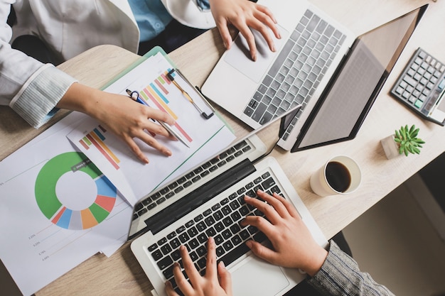 Vista superior de duas mulheres de negócios trabalhando com laptop na mesa do escritório