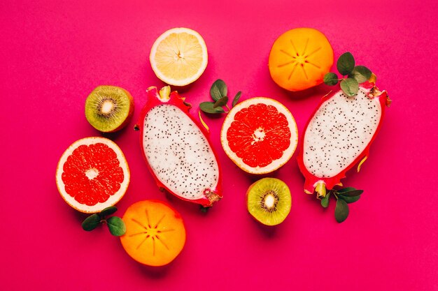 Vista superior de frutas cítricas em fundo rosa