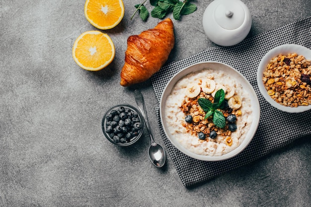 Vista superior de frutas legumes porridge chá frutas secas nozes em uma mesa cinzenta