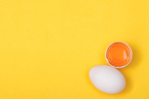 Vista superior de gema de ovo e proteína de clara de ovo boa para o fundo amarelo do corpo