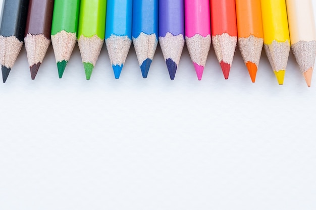 Vista superior de giz de cera colorido ou lápis de cor definido no intervalo em papel branco