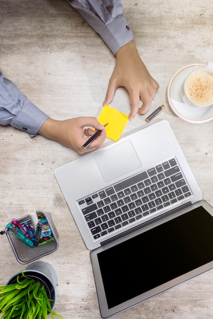 Vista superior, de, homem negócios, escrita, em, notas pegajosas, com, laptop, café, potted, planta, e, negócio, acessórios